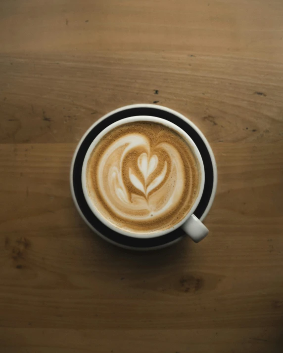 a cup with coffee in it sitting on a wooden table