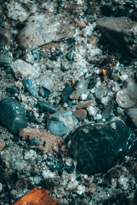 some rocks are laying on some dirt by the water