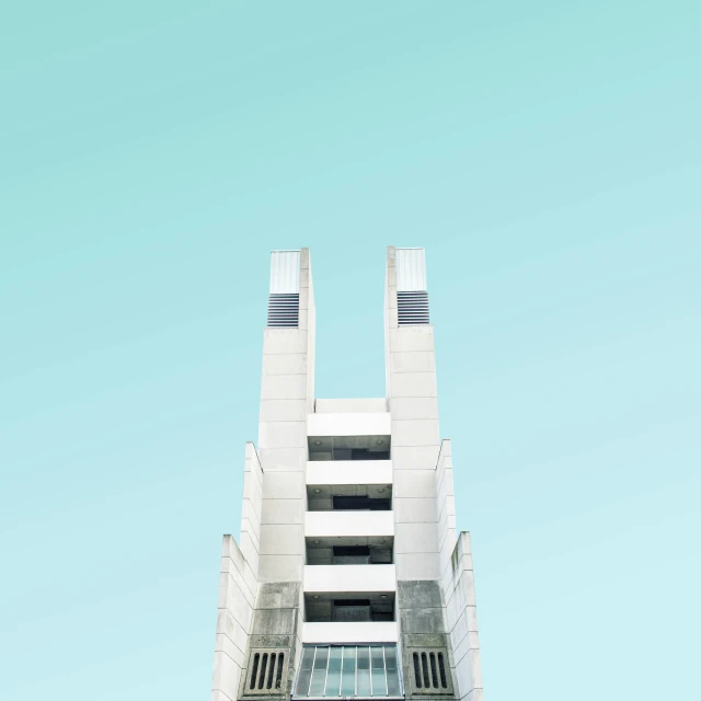 a very tall white building with two people standing on top