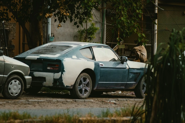 a car with white spots on it parked in the dirt