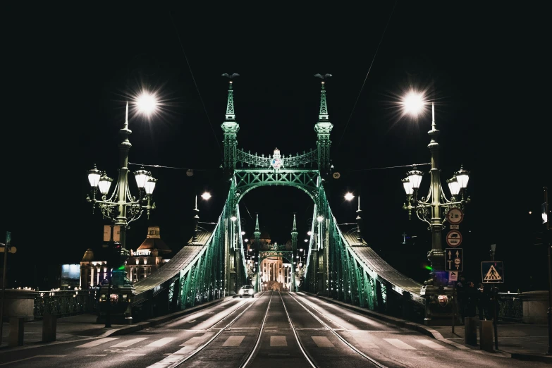 the bridge has street lamps lit up on top of it