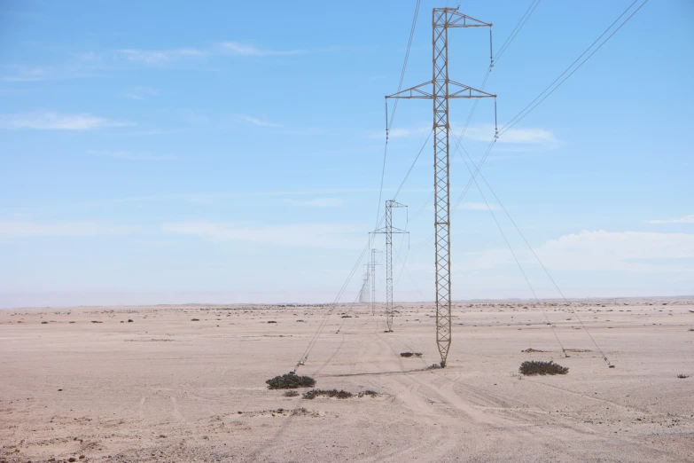 power lines stand in the middle of the desert