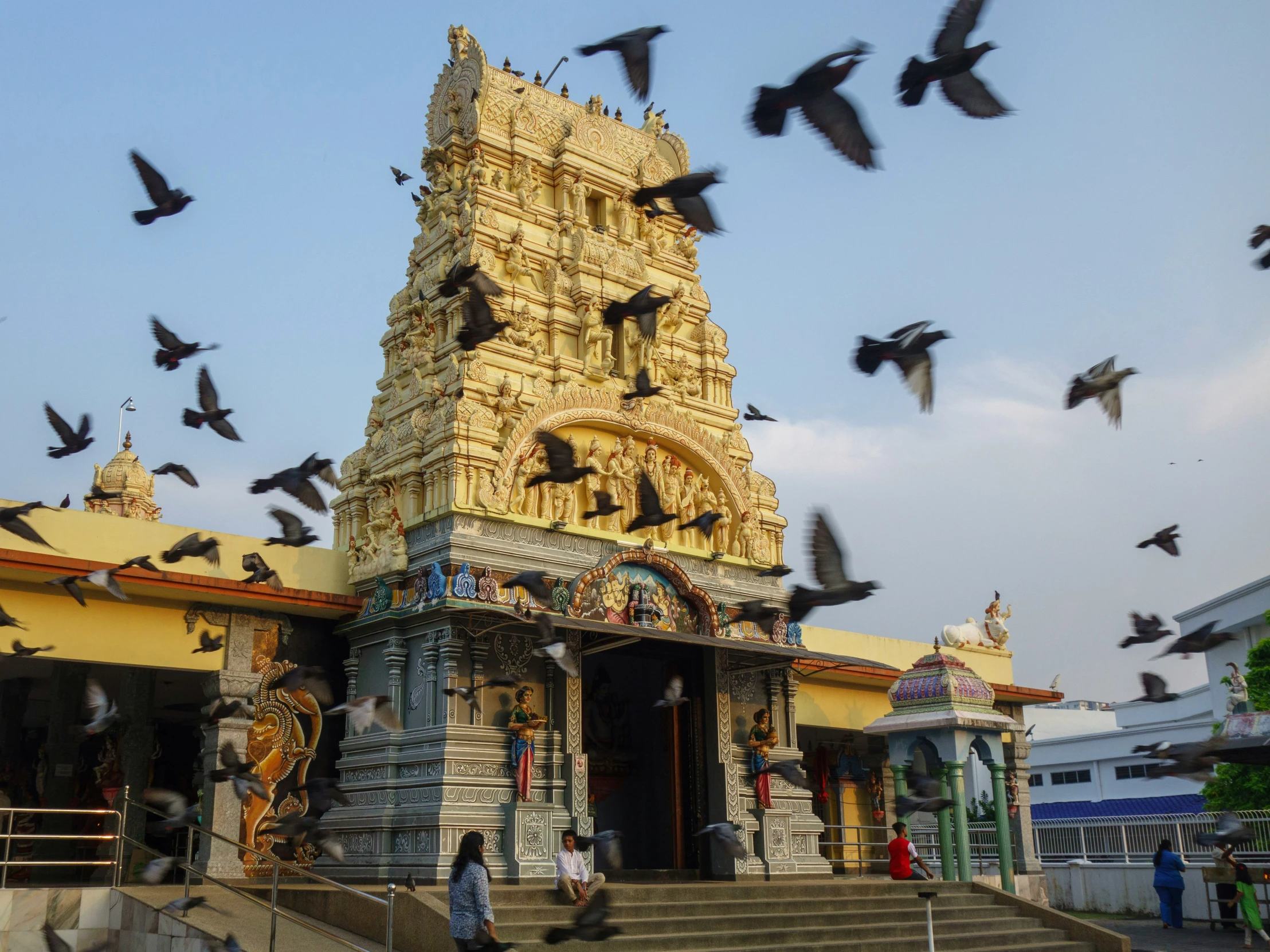 the birds fly over a building with a golden alter