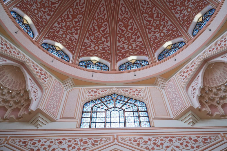 the ceiling inside the mosque has multiple arched windows and a colorful ceiling