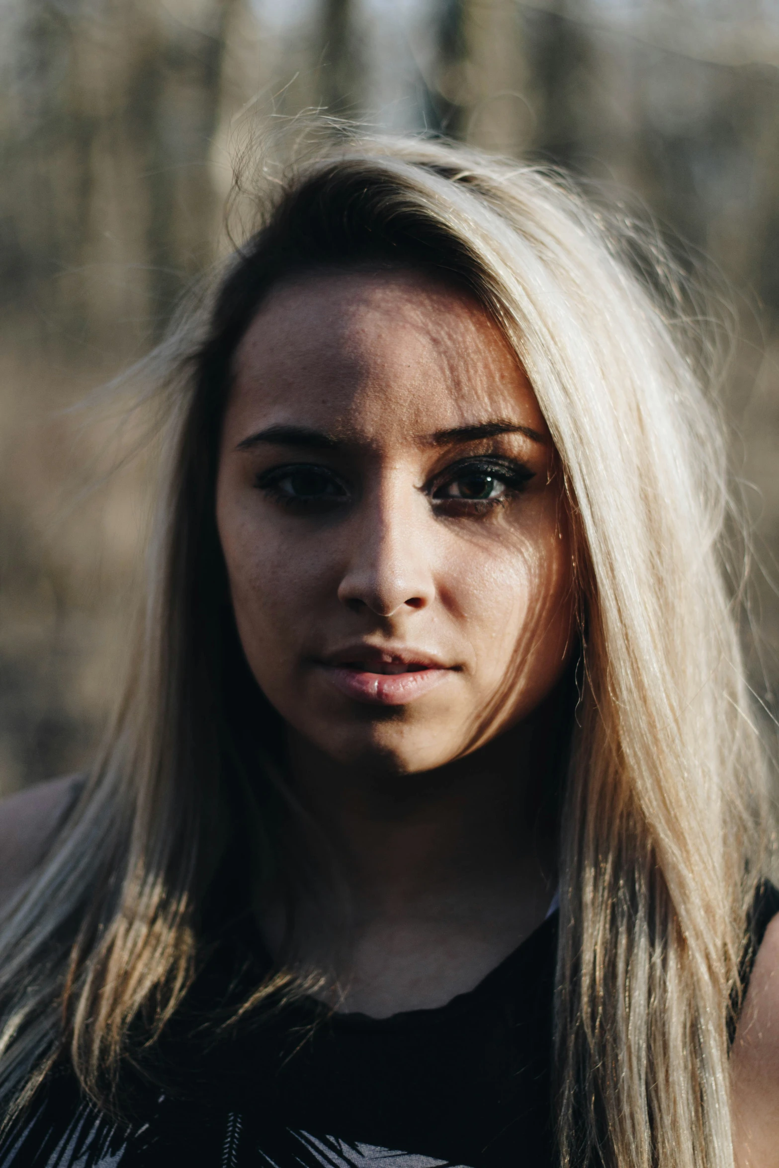 a young blond woman wearing dark clothes posing