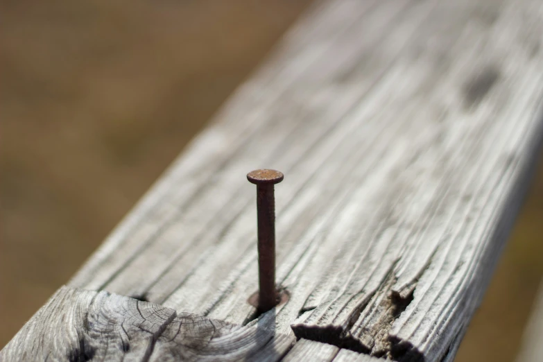 a wood bench with a nail sticking out of it