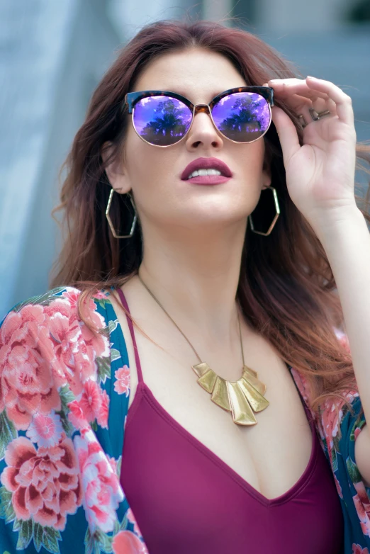 a woman with red hair wearing sunglasses posing for the camera