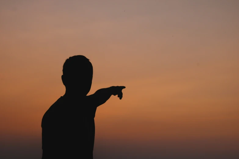 a man pointing to soing at the top of a hill