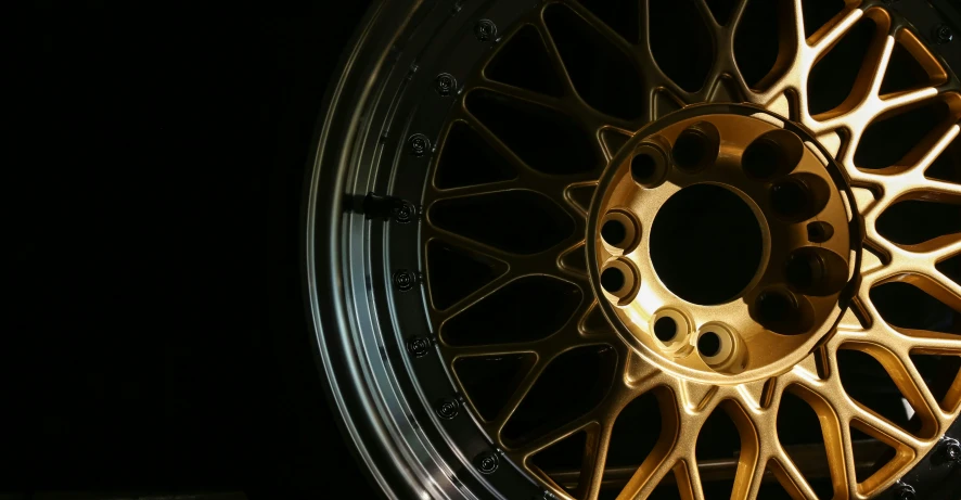 a close up of a vehicle's gold rim on a car