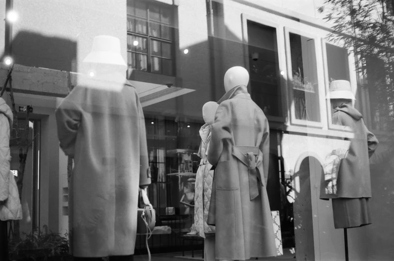 an outside window of a store with mannequins in the window