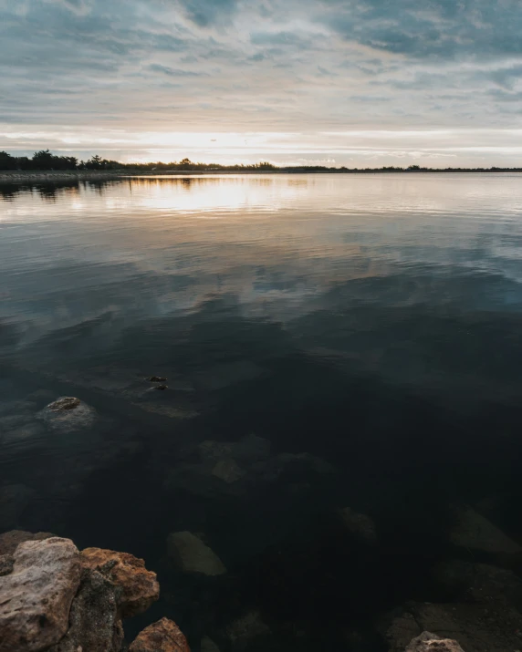 a lake is next to some rocks and trees