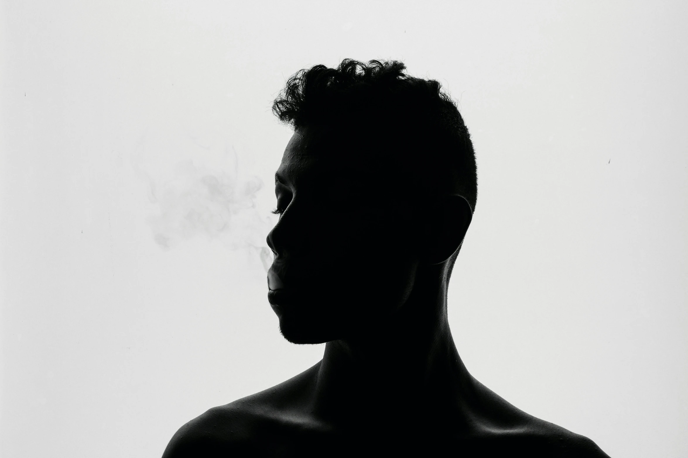 the silhouette of a man holding an electronic cigarette