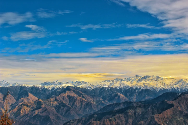 the snow - covered mountains are covered in low clouds