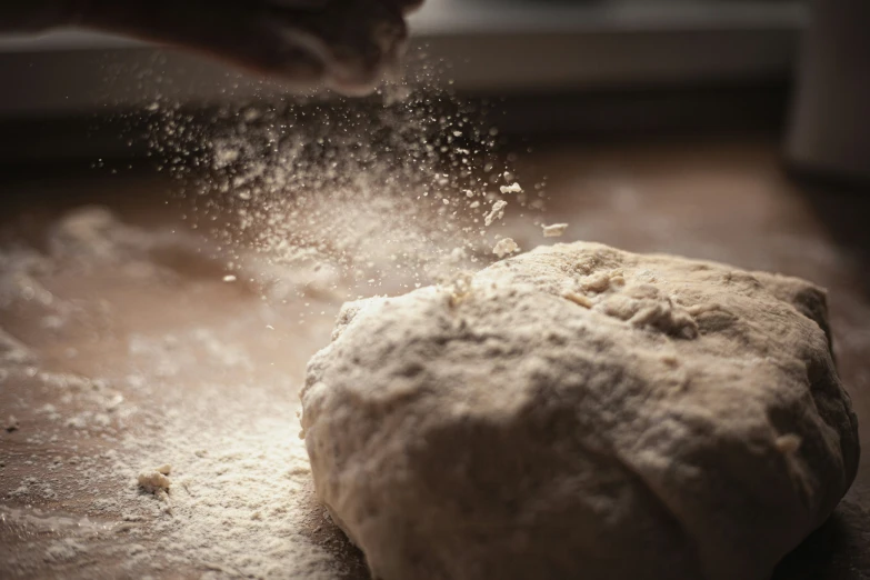 a close up of a person in flour sprinkles on dough