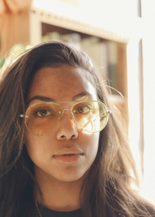 a woman in glasses stands with her hair down