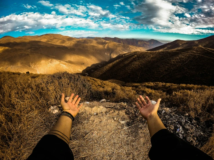 a person standing on top of a hill next to mountains