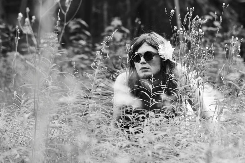 a woman in the grass with her hands behind her head