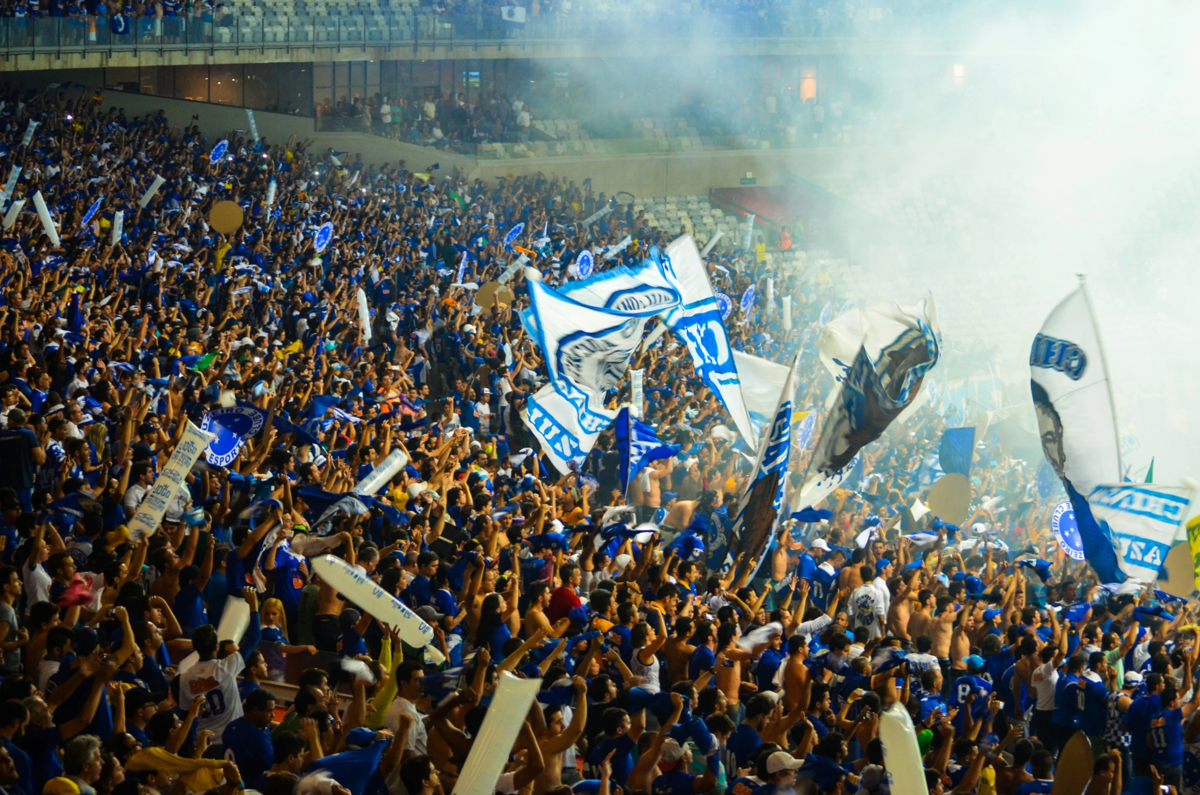 fans with flags and flarers during a sporting event