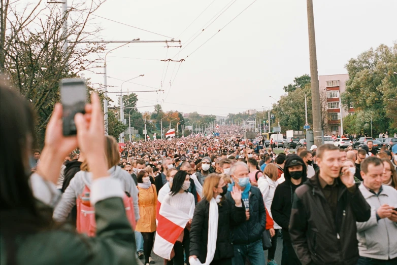 a large crowd of people walking down a street