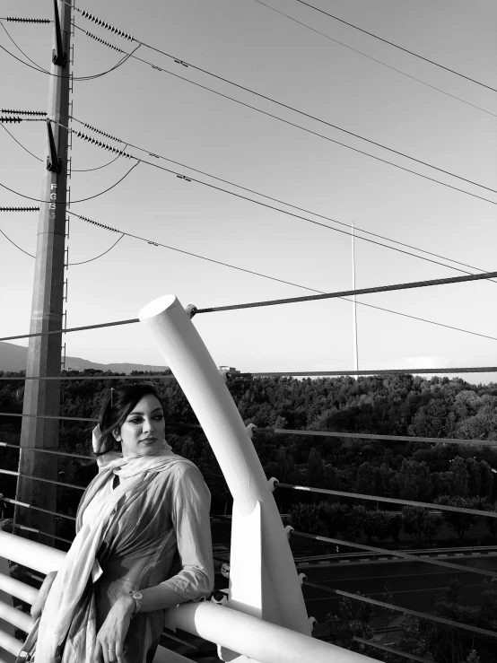 the young woman is wearing an umbrella and standing on a bench in the sun