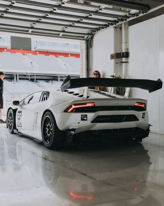 two men standing next to a racing car