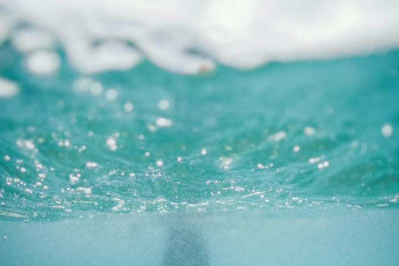 a body of water with some bubbles and blue sky above