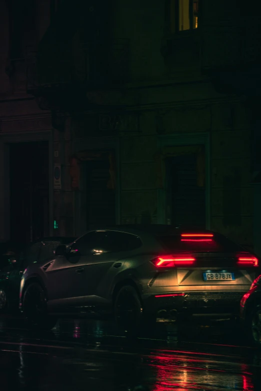 two cars driving in the rain at night