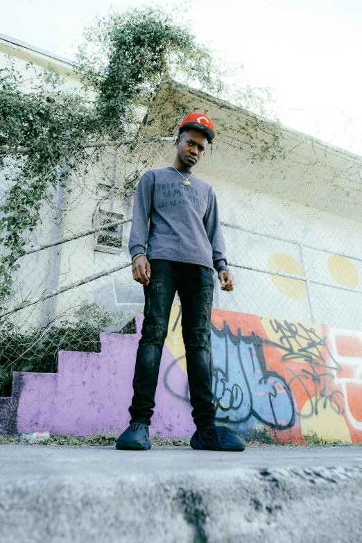 a boy standing in front of some graffiti