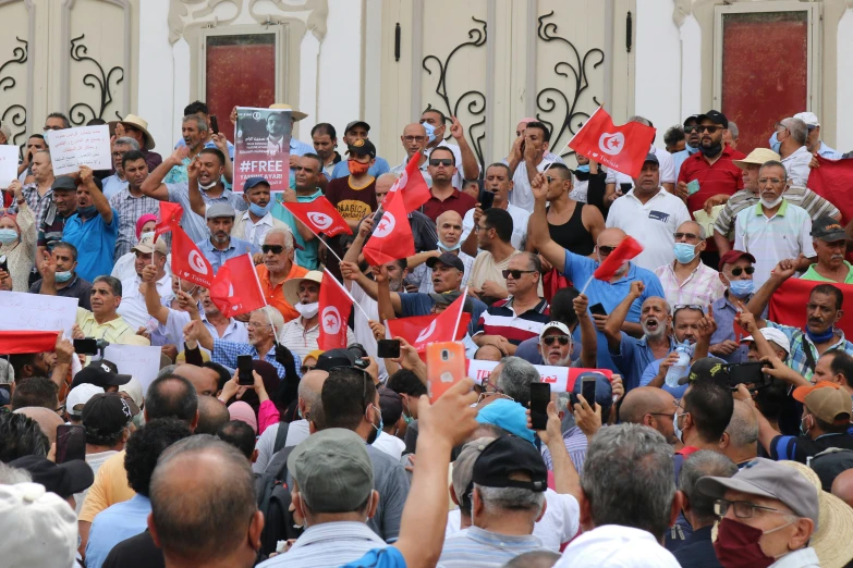 some people are holding flags and posing for pictures