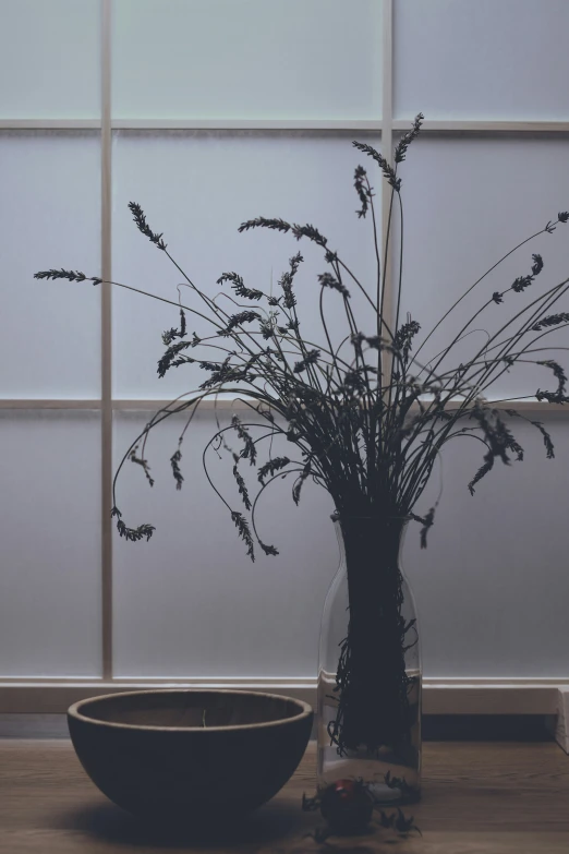a glass bowl is next to the large flower arrangement