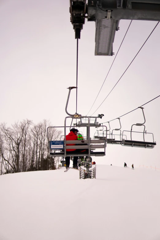 people on the bottom of a ski lift with one person under it