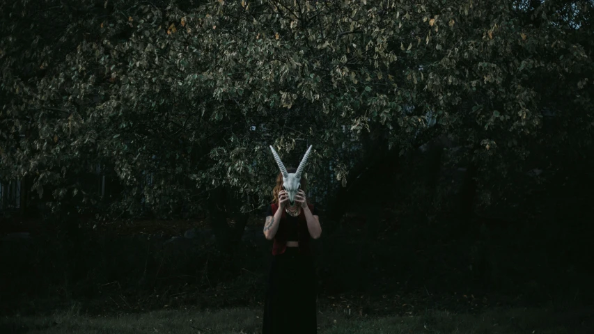 a woman wearing black holding up a white bird to her face