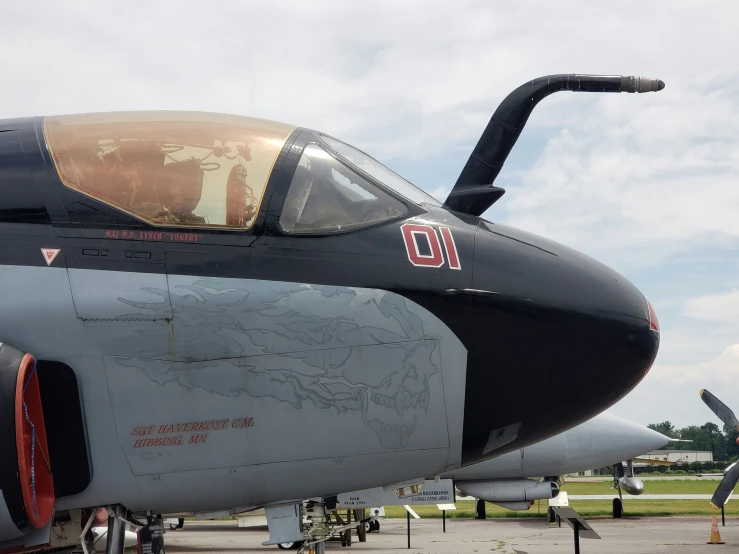 two jets are parked in a line, each with a man's hand drawing on the side