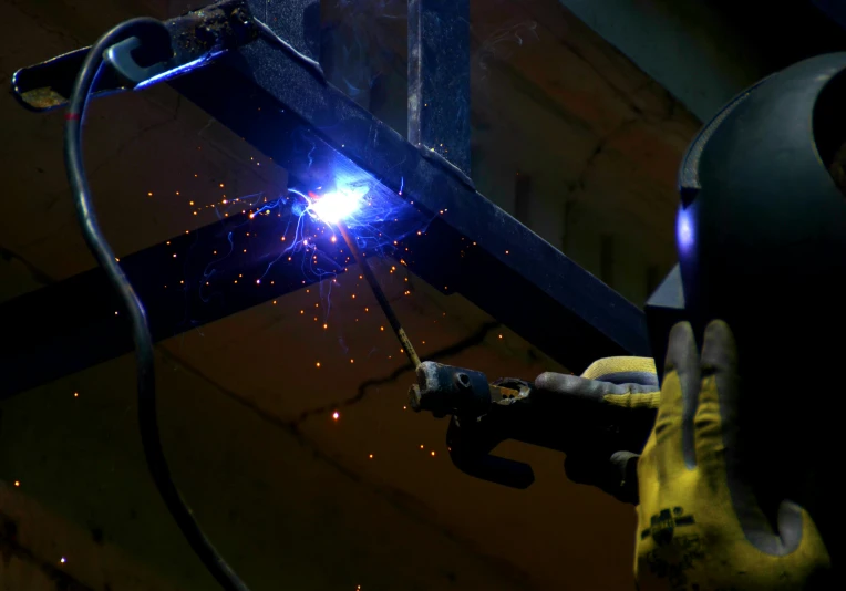 a person welding in a factory with lots of sparks