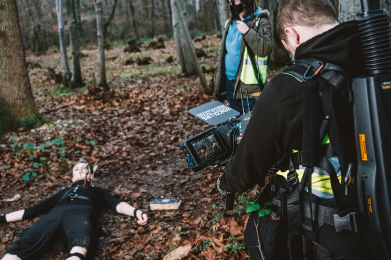 the people are taking pictures while a woman lies on the ground