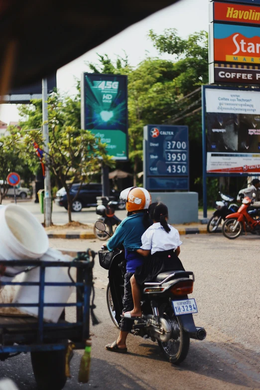 a man on a motorcycle and a woman on a bike in the street