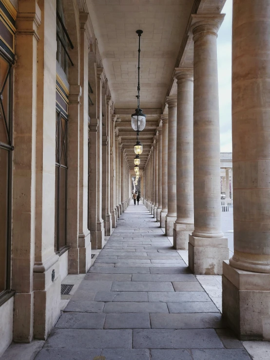 an alley with many pillars is lined with lamp posts