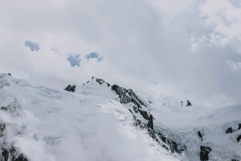 a view of mountains are covered in snow and clouds