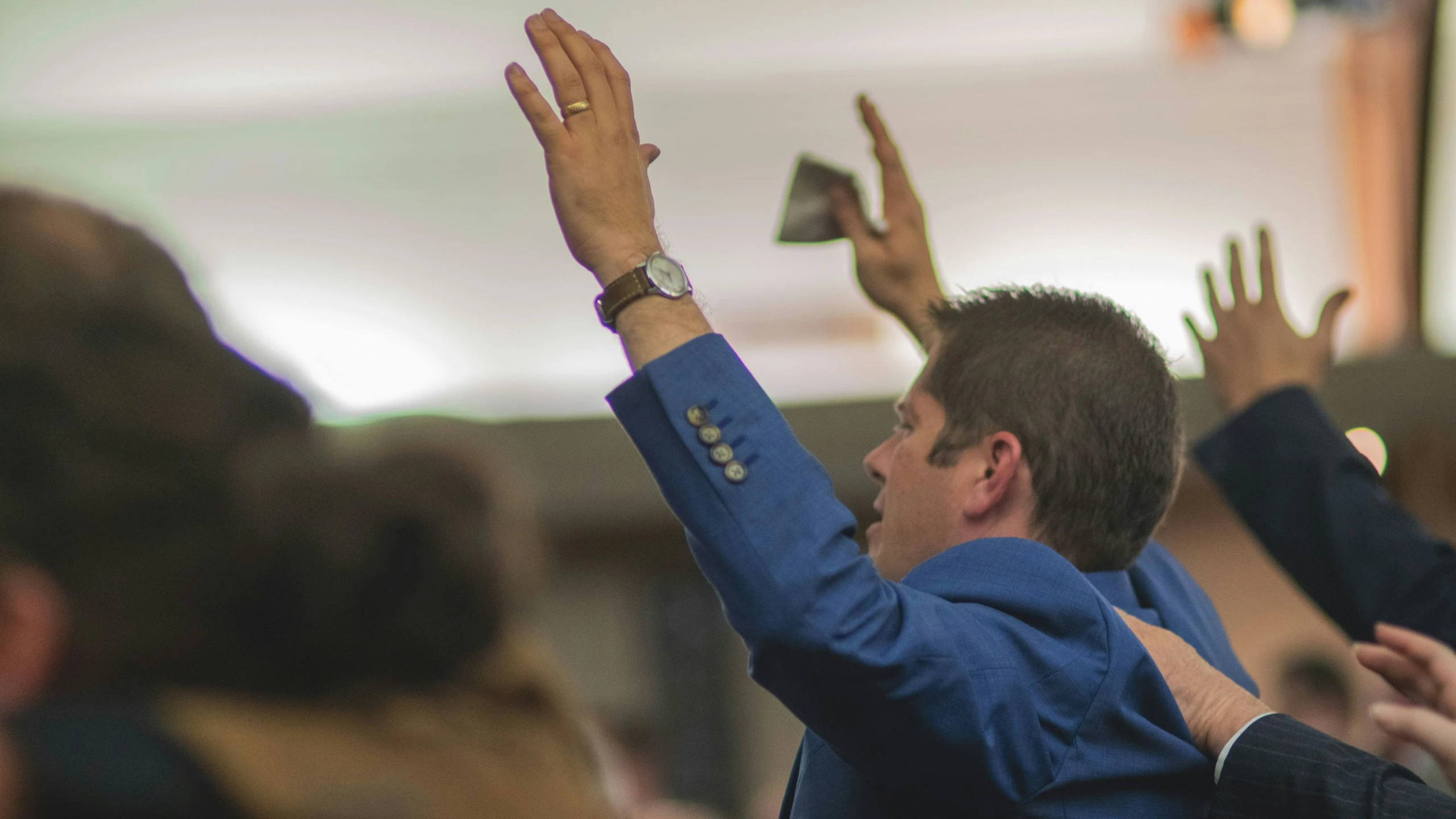 several people raising their hands in a crowd