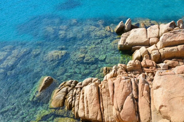 a rock shore with lots of clear water