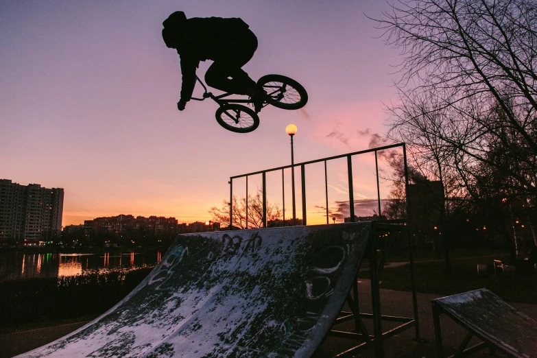 person jumping on a bmx bike over a snow covered slope