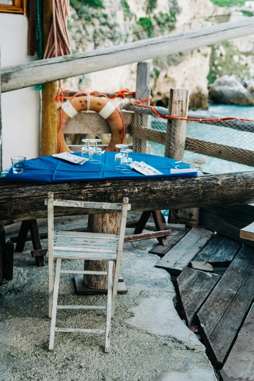 a chair sitting at a table on top of a pier