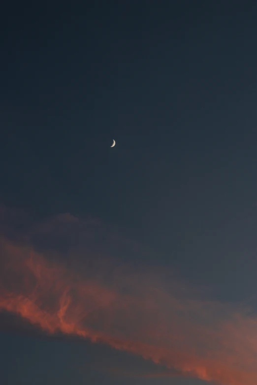 the moon is in the sky with the clouds behind it