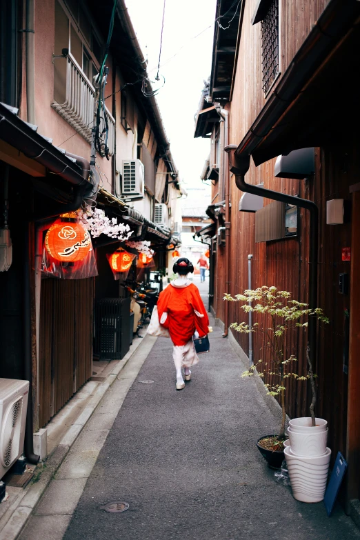 a person walking down an alley between buildings