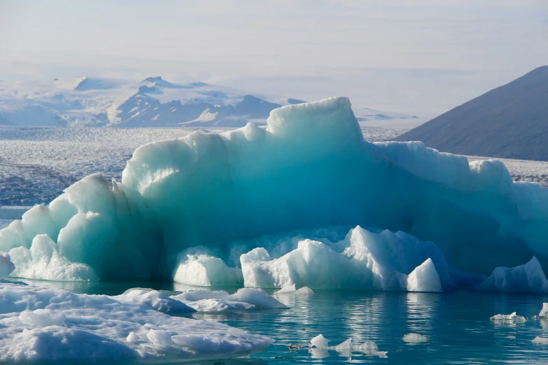 iceberg that is blue and melting over some water