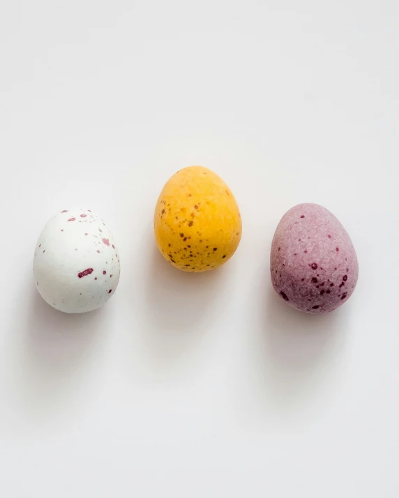 three bath bombs on a white surface