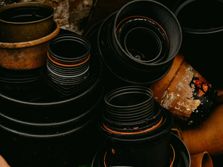 piles and piles of black plates on top of a wooden table