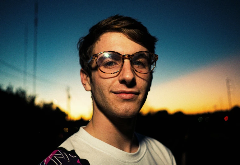 a man in glasses poses for a po