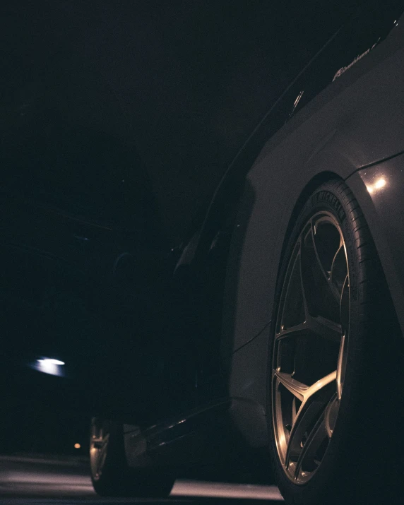 the side of a dark car with a white tire