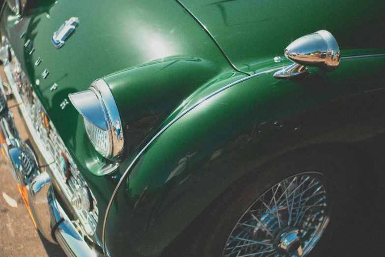 a close up s of the front and side of a vintage green car